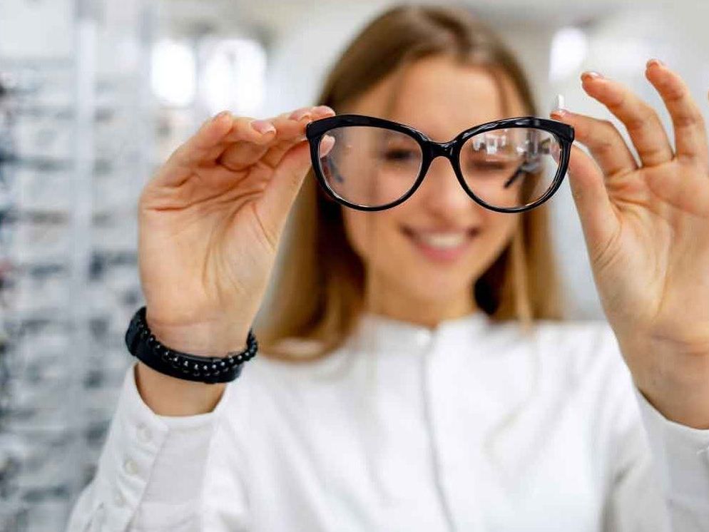 An optician checking the lenses on a pair of glasses 
