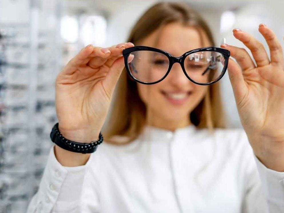 An optician checking the lenses on a pair of glasses